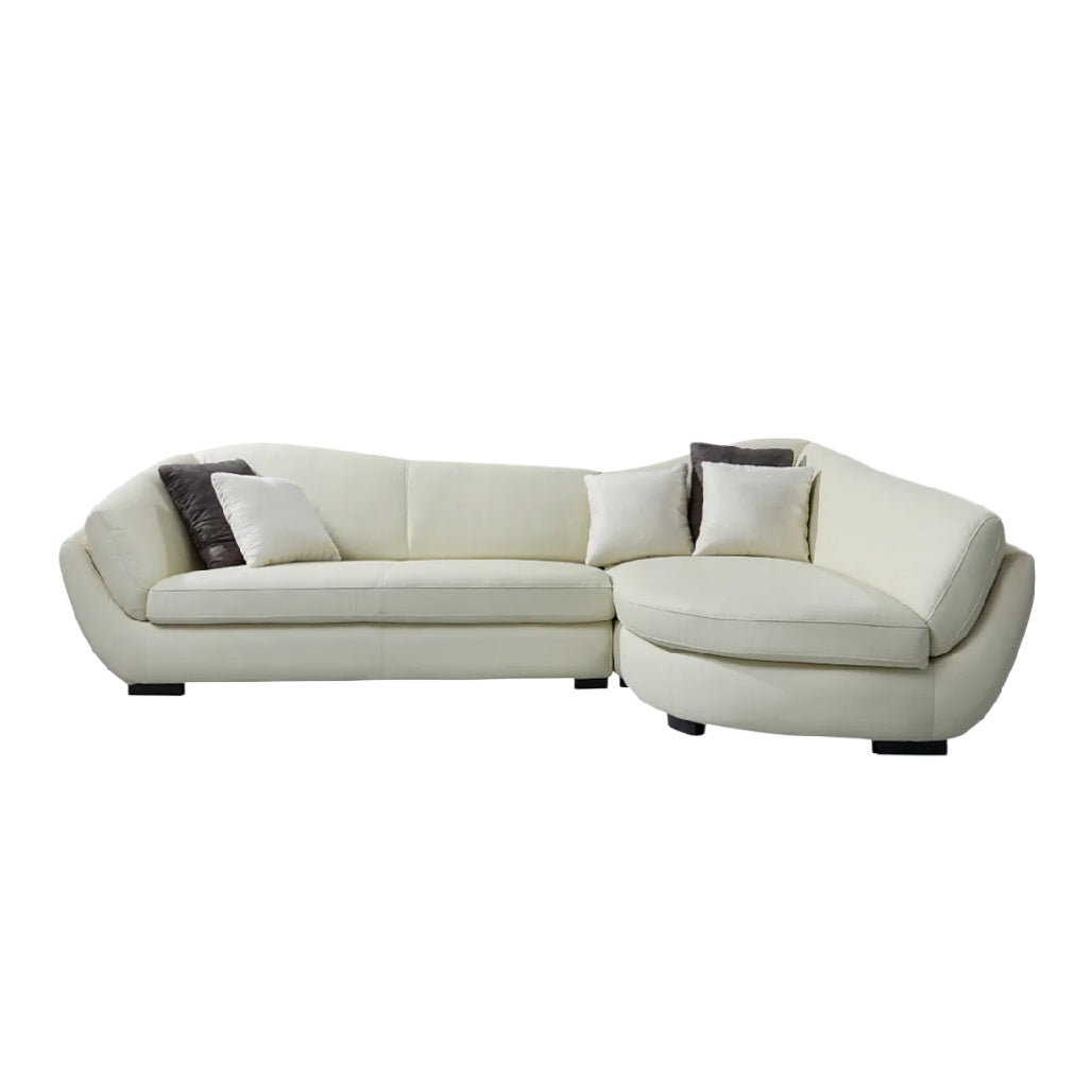 Canapé d'angle en simili cuir blanc avec coussins décoratifs.